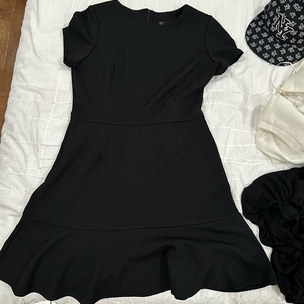 black flowy dress that’s fitted around the waist and torso